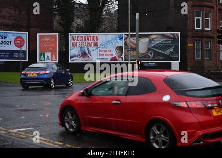 Greenock, Scozia, Regno Unito. 20 febbraio 2021. Nella foto: Immagine del primo ministro scozzese Nicola Sturgeon con la grafica di un vaccino COVID19 e una siringa con lo slogan: "VACCINAZIONE NON SEPARAZIONE. FAI IL TUO LAVORO, PRIMO MINISTRO." su un cartellone nel mezzo di Greenock, in un crocevia trafficato di Brougham St & Campbell St. Questo è in riferimento alla maggioranza silenziosa di persone in Scozia che si oppongono alla SNP cercando un secondo referendum sull'indipendenza nel mezzo di una pandemia che lo ha fatto Nel Regno Unito sono state uccise oltre 106,000 persone, di cui 6,816 nella sola Scozia. Credit: Colin Fisher/Alamy Live News. Foto Stock