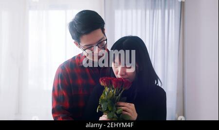 Buon anniversario. Il marito sorprende la moglie con bouquet di rose rosse. Foto di alta qualità Foto Stock