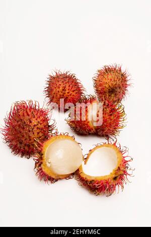 Frutta fresca rambutan esposta con varietà aperte e chiuse su uno sfondo pulito in un ambiente studio Foto Stock