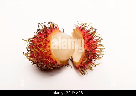 Frutta fresca rambutan esposta con varietà aperte e chiuse su uno sfondo pulito in un ambiente studio Foto Stock