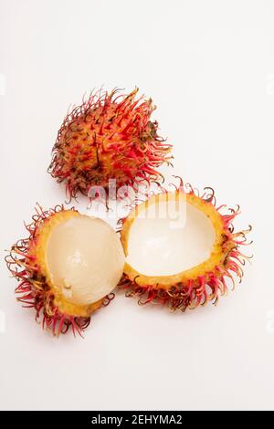 Frutta fresca rambutan esposta con varietà aperte e chiuse su uno sfondo pulito in un ambiente studio Foto Stock