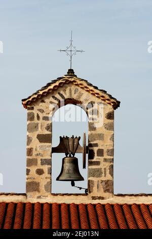 Campanile con una bella campana sotto il cielo azzurro in un villaggio in Alvernia Rhône-Alpes, Francia Foto Stock