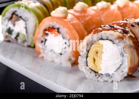 Gustosi panini freschi di sushi preparati sotto forma di drago con zenzero e wasabi. Cucina giapponese Foto Stock