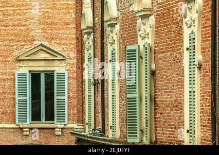 Finestre in legno, dipinte di verde in un muro di mattoni rossi di un palazzo medievale. Fabriano, provincia di Ancona, Marche, Italia, Europa Foto Stock