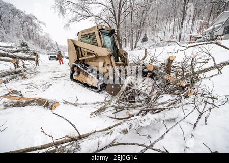 Ceredo, Stati Uniti. 19 Feb 2021. Soldati degli Stati Uniti con la West Virginia National Guard eliminare i detriti da una tempesta invernale fuori di una strada 19 febbraio 2021 a Ceredo, Wayne County, West Virginia. Un grande sistema di tempeste invernali all'inizio della settimana ha lasciato più di 90,000 West Virginia senza elettricità in tutta la regione, abbattendo gli alberi e rendendo le strade remote impassabili. Credit: Planetpix/Alamy Live News Foto Stock