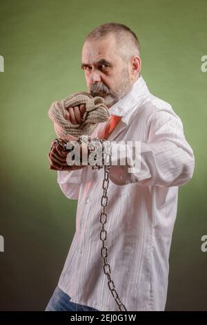 Uomo anziano aggressivo con una catena in mano Foto Stock