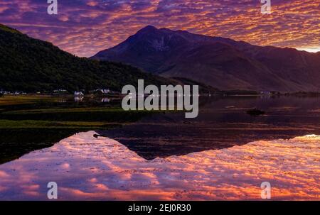 Un tramonto ardente su Beinn a Bheithir riflesso in Loch Linnhe, Highlands scozzesi Foto Stock