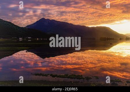 Un tramonto ardente su Beinn a Bheithir riflesso in Loch Linnhe, Highlands scozzesi Foto Stock