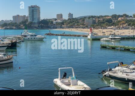 Palmanova, Spagna; febbraio 20 2021: Vista generale del porto turistico e della spiaggia della località di Palmanova in una giornata di sole, con le famiglie che si godono t Foto Stock