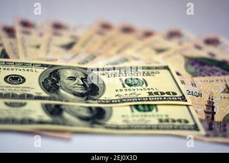 Fuoco selettivo della valuta nazionale dell'Egitto con le banconote del dollaro degli Stati Uniti. Soldi offuscati . Valuta egiziana e tasso di cambio dollari americani,. Foto Stock