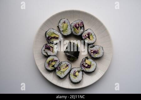 Un piatto che contiene porzioni di sushi vegetariano fatto in casa Foto Stock