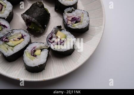 Un piatto che contiene porzioni di sushi vegetariano fatto in casa Foto Stock