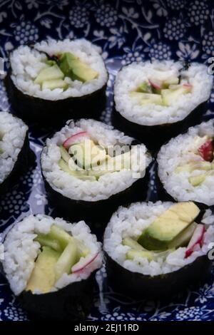 Un piatto che contiene porzioni di sushi vegetariano fatto in casa Foto Stock