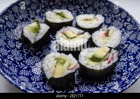 Un piatto che contiene porzioni di sushi vegetariano fatto in casa Foto Stock