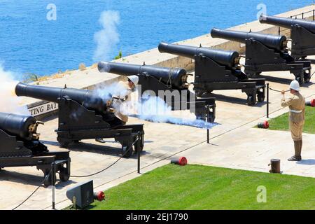 Sparatori che sparano una pistola SBBL 32-passera alla batteria di Saluting dei Giardini superiori di Barrakka a la Valletta, Malta Foto Stock