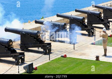 Sparatori che sparano una pistola SBBL 32-passera alla batteria di Saluting dei Giardini superiori di Barrakka a la Valletta, Malta Foto Stock