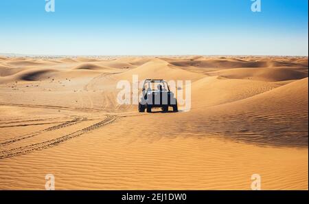 Giro in quad in buggy in avanti sulla sabbia del deserto, lascia tracce, splendido paesaggio naturale selvaggio, guida fuori strada all'aperto Foto Stock