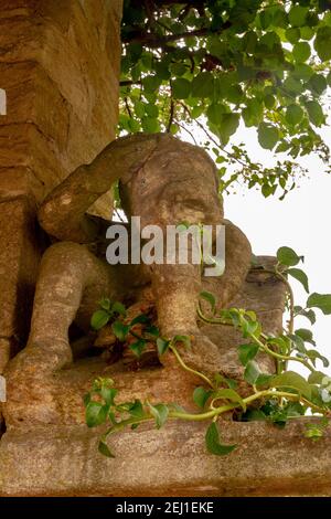 Antica scultura circondata da piante Foto Stock