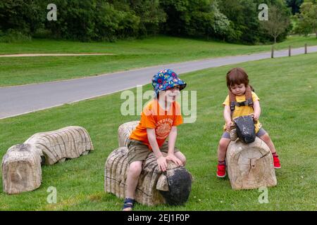 Bambini che giocano in un campo con alcuni animali di legno Foto Stock