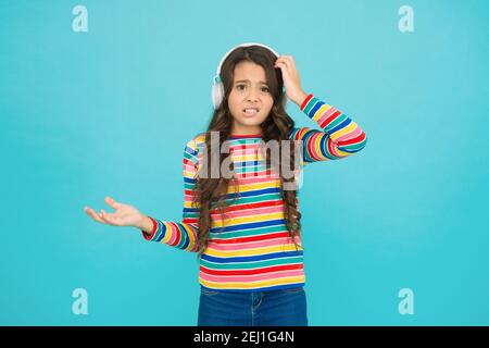 la ragazza ascolta la musica con le cuffie. audiolibro per bambini. bambino stupisco. scolaretta indossa abiti colorati. guida preferita. musica radio. la sua playlist speciale. vita moderna. Ha ottenuto grande stile. Foto Stock
