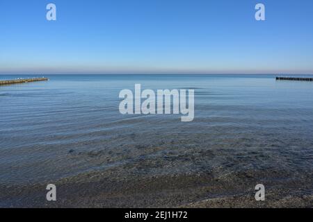 Vista all'orizzonte sulla spiaggia del Mar Baltico incorniciata da filari di groynes, natura sfondo concetto per l'ambiente e il turismo, copia spazio, selec Foto Stock
