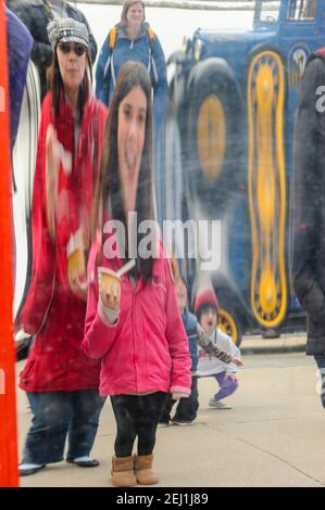 Specchio funhouse, l'immagine di una giovane ragazza che indossa una giacca rossa si riflette sulla superficie di uno specchio distorsivo a Navy Pier, Chicago, Illinois. Foto Stock