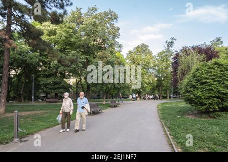 BELGRADO, SERBIA - 14 MAGGIO 2020: Sfocatura selettiva su anziano e donna, coppia, indossando una maschera respiratoria, svegliandosi in un parco di Belgrado, du Foto Stock