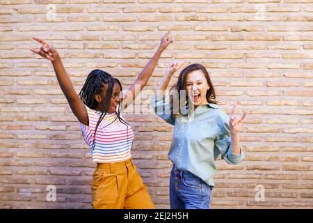 Due amiche che si divertono insieme per strada. Amici multietnici. Foto Stock