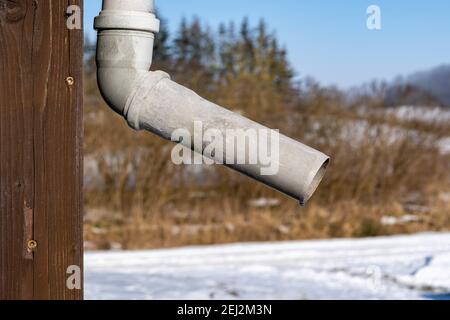 Un primo piano di un vecchio drainpipe contro un legno parete Foto Stock