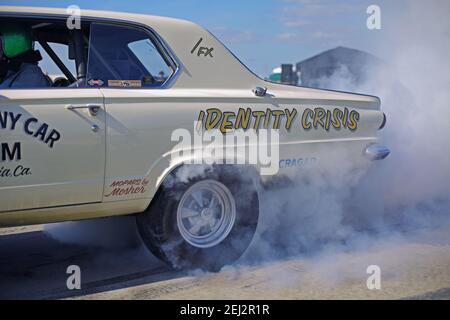 Muscle car che esegue un burnout a Racetrack.Close up di ruota di auto da corsa americana, pneumatico bruciante per fumare. Foto Stock