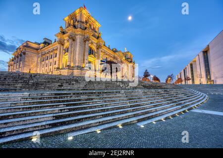Il Reichstag illuminato a Berlino visto dal fiume Sprea all'alba Foto Stock