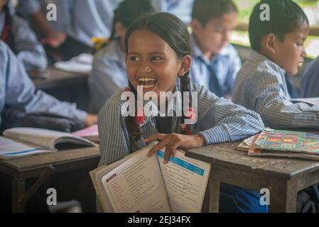 Pokhara, Nepal. 09-15-2017. Ragazza di un villaggio sulle montagne del Nepal sta frequentando la scuola e ride in classe. Foto Stock