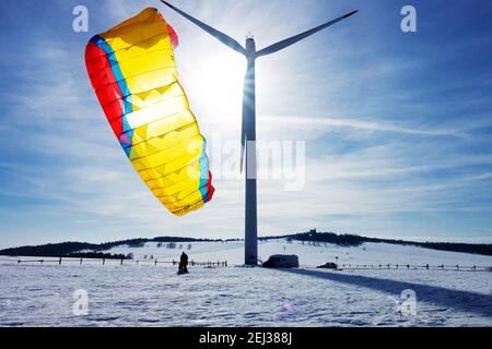 Sport invernali in neve, aquilone sulla neve aperto contro il cielo con sole, turbina eolica invernale panoramica turbine eoliche neve neve ambiente invernale Krusne Hory Erzgebirge Foto Stock