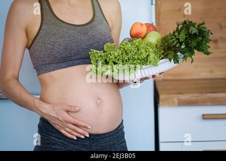 Donna incinta pancia e verdure. Gravidanza, cibo sano e concetto di persone Foto Stock