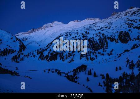 Alba invernale sulla cima di Aneto e sul massiccio del Maladetas, vista dal Plan d'Aigualluts (Valle del Benasque, Pirenei, Spagna) Foto Stock