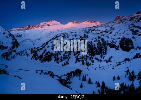 Alba invernale sulla cima di Aneto e sul massiccio del Maladetas, vista dal Plan d'Aigualluts (Valle del Benasque, Pirenei, Spagna) Foto Stock