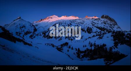 Alba invernale sulla cima di Aneto e sul massiccio del Maladetas, vista dal Plan d'Aigualluts (Valle del Benasque, Pirenei, Spagna) Foto Stock