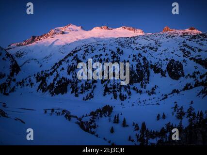 Alba invernale sulla cima di Aneto e sul massiccio del Maladetas, vista dal Plan d'Aigualluts (Valle del Benasque, Pirenei, Spagna) Foto Stock