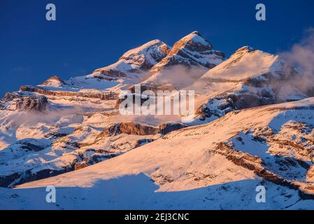 Tramonto invernale sulla vetta del Monte Perdido e sulle cime del Soum de Ramond e Punta de las Olas (Ordesa e Parco Nazionale del Monte Perdido, Pirenei, Spagna) Foto Stock