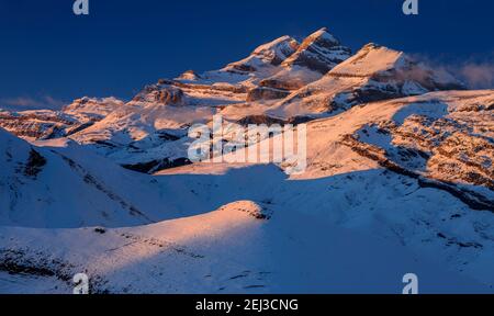 Tramonto invernale sulla vetta del Monte Perdido e sulle cime del Soum de Ramond e Punta de las Olas (Ordesa e Parco Nazionale del Monte Perdido, Pirenei, Spagna) Foto Stock