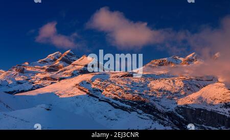 Tramonto invernale sulla vetta del Monte Perdido e sulle cime del Soum de Ramond e Punta de las Olas (Ordesa e Parco Nazionale del Monte Perdido, Pirenei, Spagna) Foto Stock