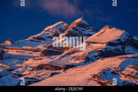 Tramonto invernale sulla vetta del Monte Perdido e sulle cime del Soum de Ramond e Punta de las Olas (Ordesa e Parco Nazionale del Monte Perdido, Pirenei, Spagna) Foto Stock