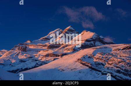 Tramonto invernale sulla vetta del Monte Perdido e sulle cime del Soum de Ramond e Punta de las Olas (Ordesa e Parco Nazionale del Monte Perdido, Pirenei, Spagna) Foto Stock