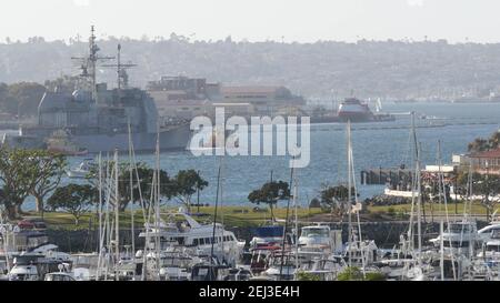 SAN DIEGO, CALIFORNIA USA - 13 FEB 2020: Rimorchiatore che tira USS Chosin CG-65, nave da guerra militare della flotta della Marina degli Stati Uniti. Rimorchiatore corazzato marittimo nel porto h Foto Stock