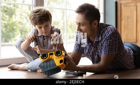 Primo piano su padre premuroso e bambino che fissa l'auto giocattolo Foto Stock