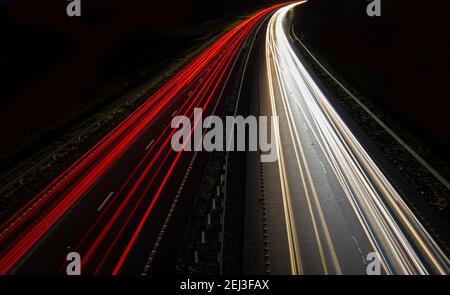 Sentieri al semaforo su una strada di notte Foto Stock