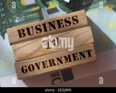 Business to Government B2G su blocchi di legno messo su centinaia di euro fatture che rappresentano Business 2 modello di marketing governativo. Concetto aziendale. Foto Stock