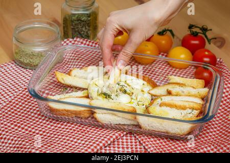 Camambrato cotto con aglio e spezie. Affondare a mano il pane croccante nel formaggio fuso Foto Stock