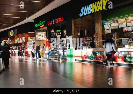 WROCLAW, POLONIA - 1 FEBBRAIO 2021. Persone con maschere facciali nella zona gastronomica del centro commerciale Magnolia. A causa di restrizioni, il cibo è solo sol Foto Stock