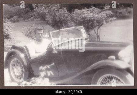 Foto in bianco e nero d'epoca di un giovane bell'uomo in un'auto MGA anni '30. Foto Stock